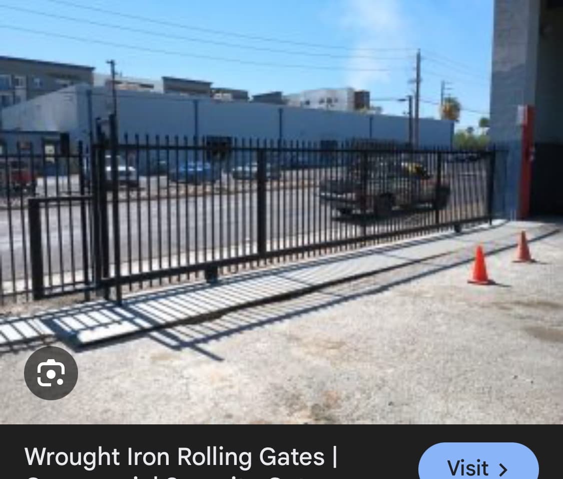 Reference photo of a black industrial rolling gate with matching pedestrian access gate