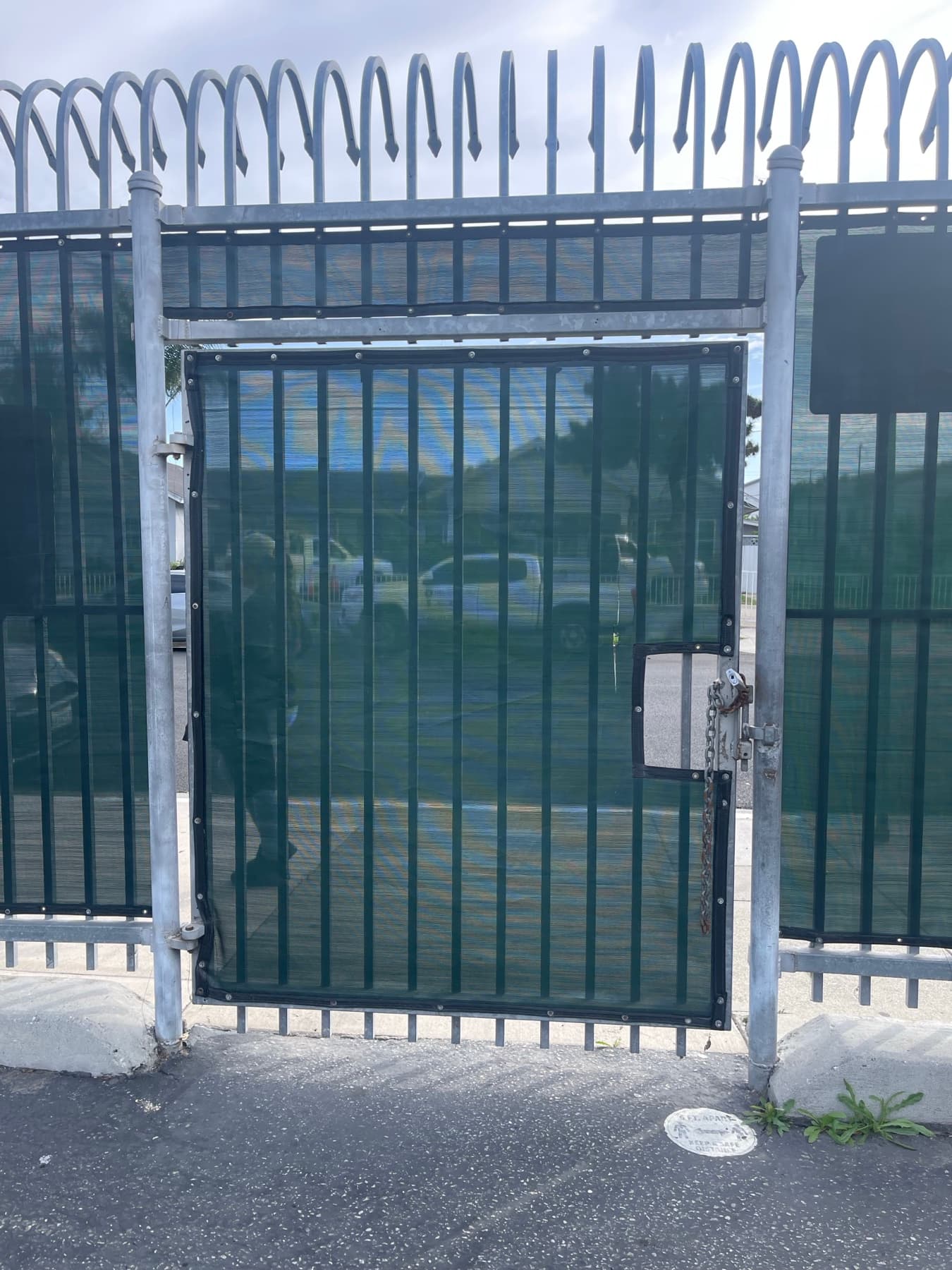 Black security screen gate installed inside a commercial perimeter fence