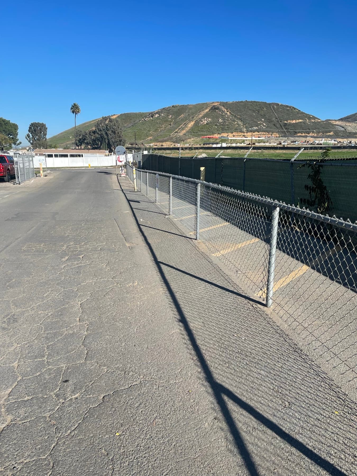 Chain link perimeter fence installed along a hillside commercial edge