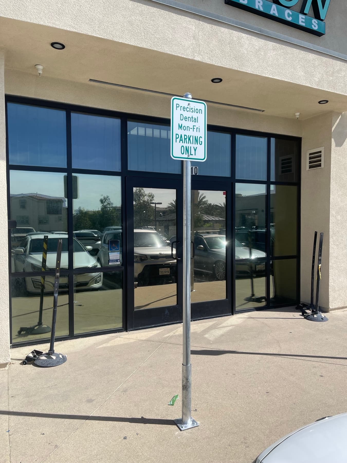Front view of a dental office parking sign post installation