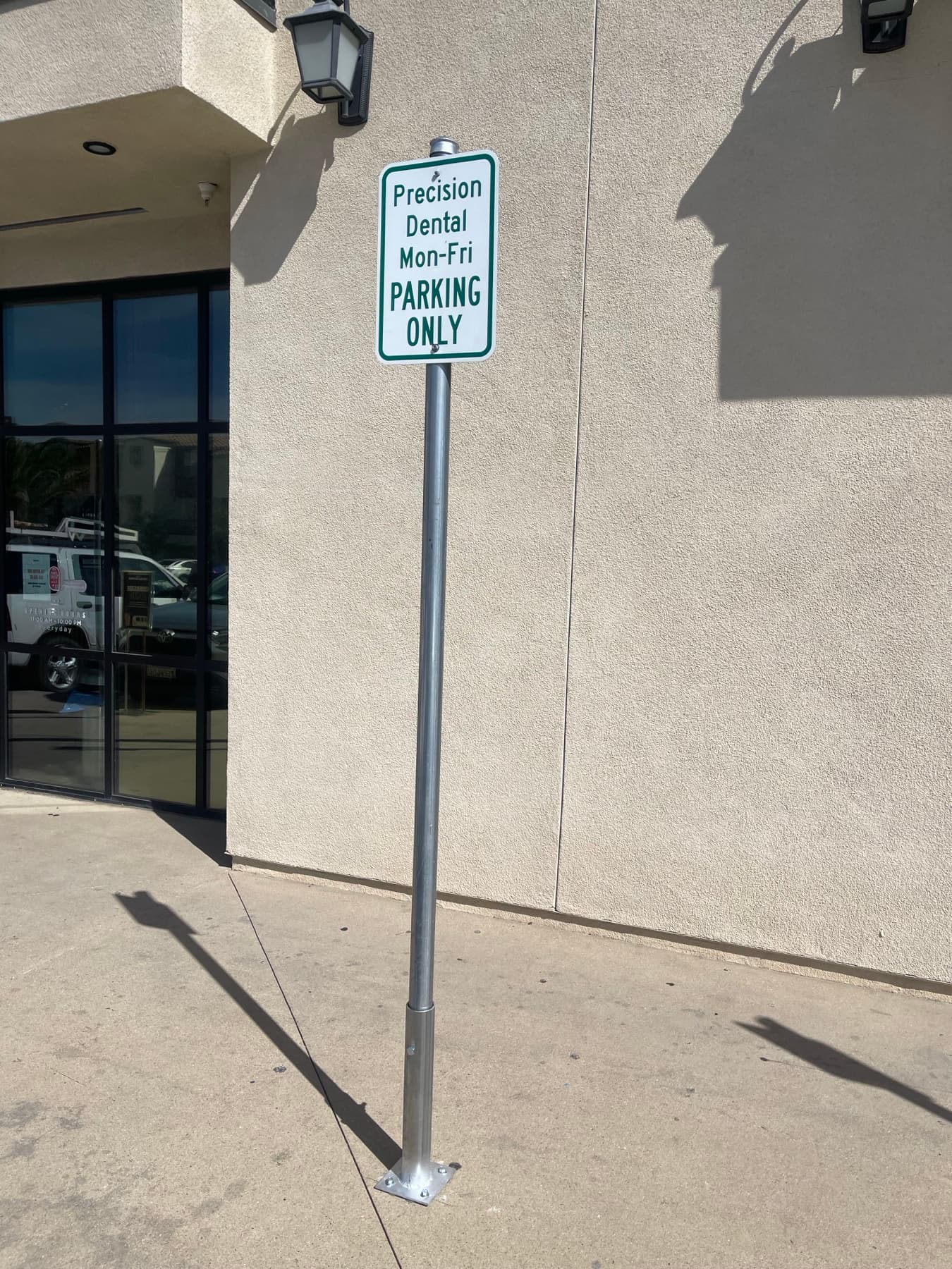 Side view of a dental office parking sign post installation