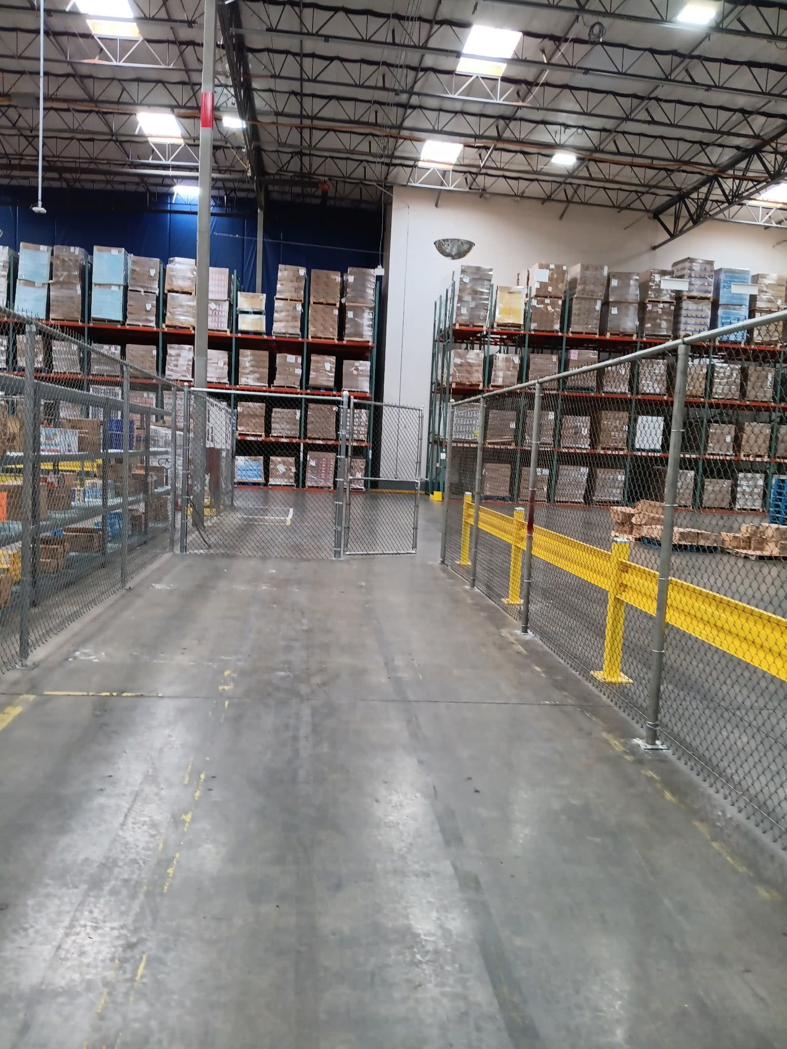 Long warehouse storage corridor secured with chain link partitions
