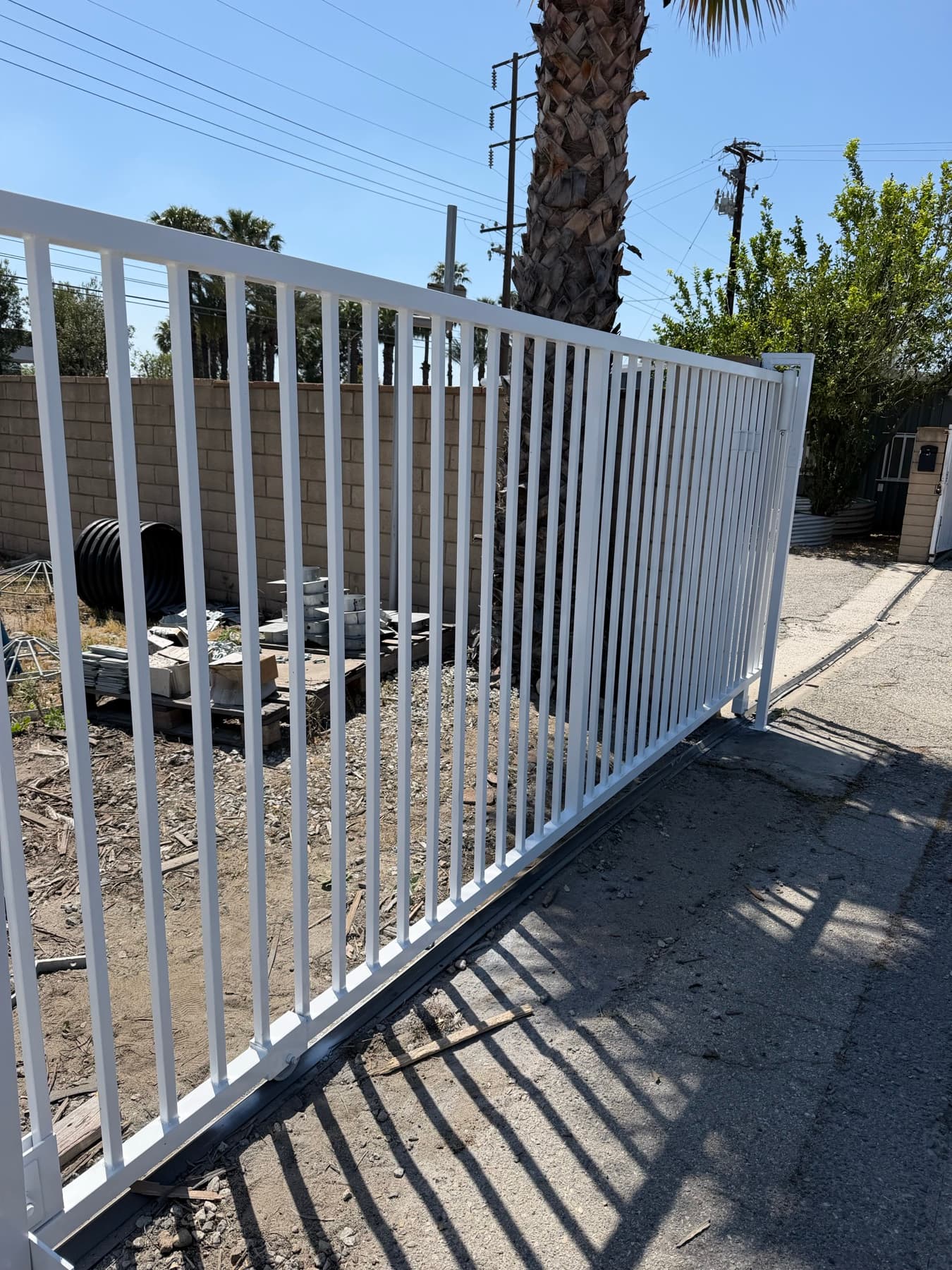 Long run view of a white commercial sliding gate installation